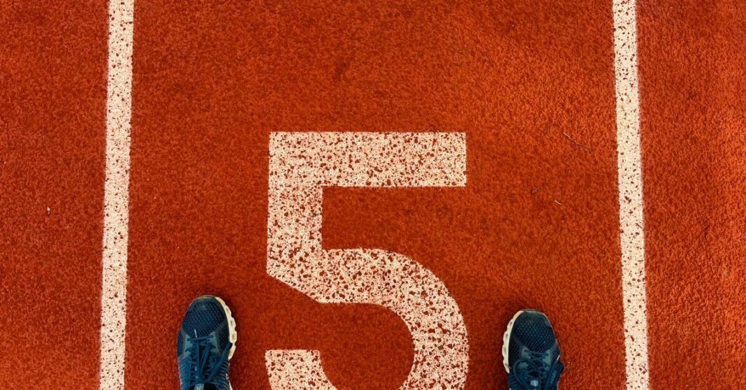 Runner's feet on track lane 5 at the finish line, symbolizing completion and success.