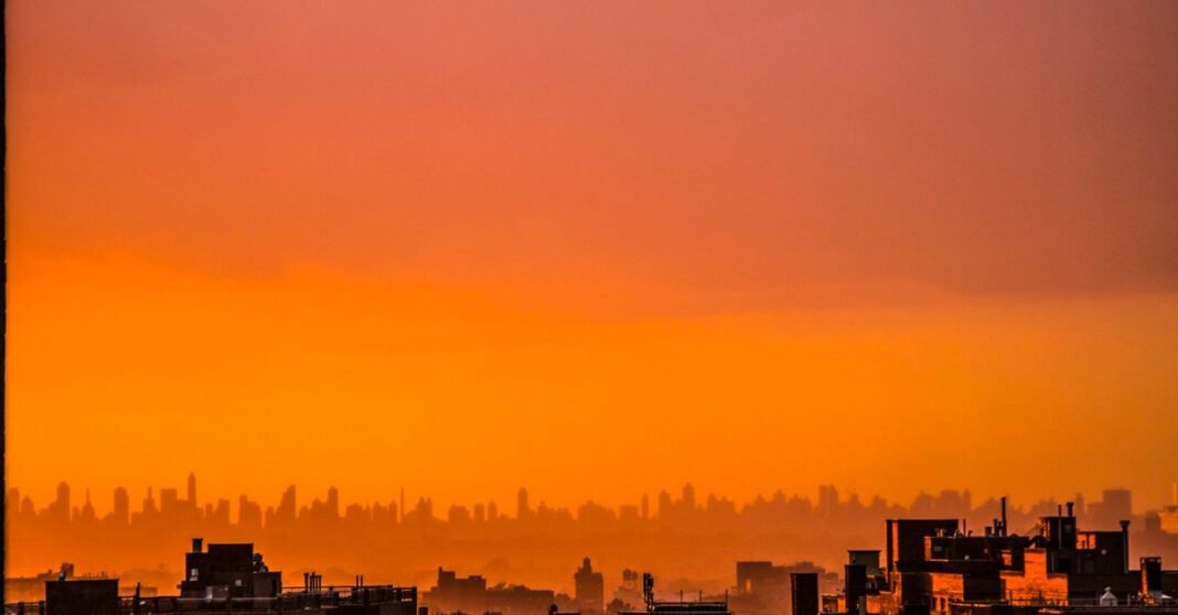 Capture the beauty of an urban skyline at sunset with warm orange hues and silhouetted buildings.
