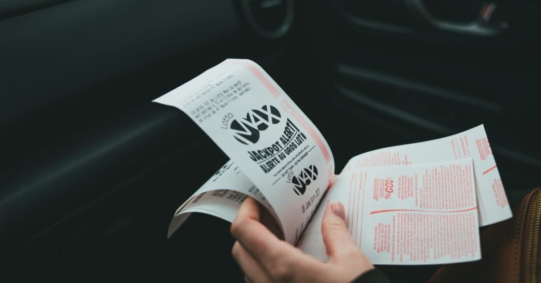 Close-up of hands holding Lotto Max papers inside a car, symbolizing luck and chance.