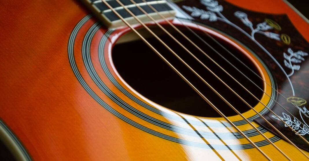 Detailed view of an acoustic guitar's strings and sound hole with intricate design.