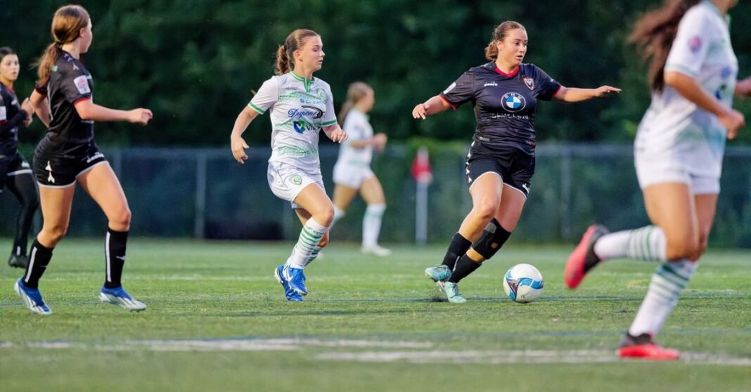 Dynamic action shot of female soccer players in motion during a game on a grass field.