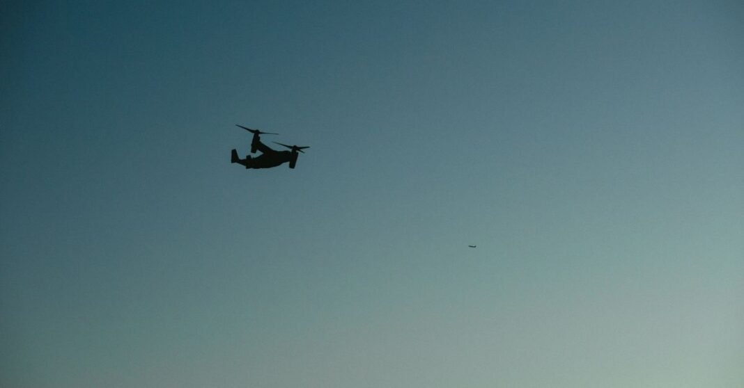 Silhouette of a military aircraft flying against a serene evening sky.