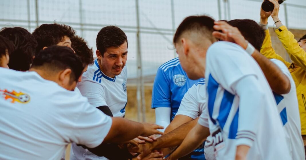 A soccer team gathers in a huddle for motivation before a match, fostering teamwork and unity.