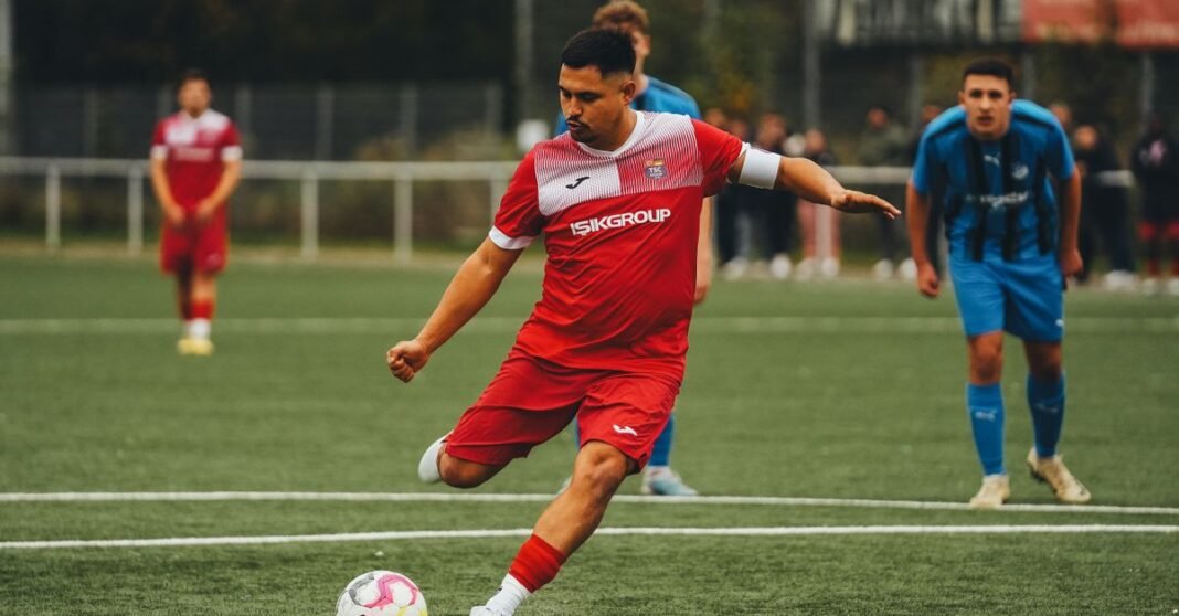 Football player in action on the pitch, showcasing athletic skill.
