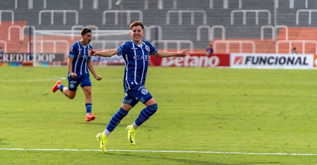 Excited soccer players celebrate a goal on the field during a match.