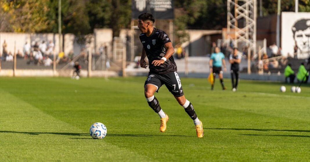 Soccer player dribbling the ball during a daytime match outdoors.