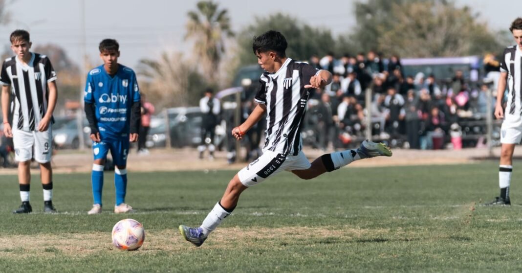 A young soccer player in action, taking a powerful kick during a competitive outdoor match.