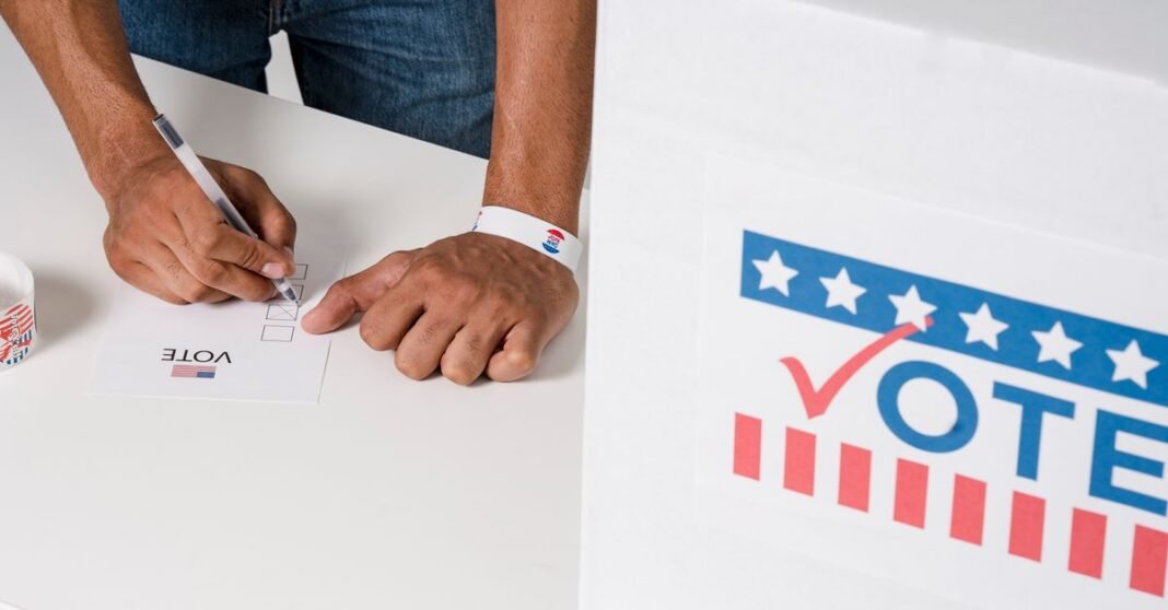 A person casting a vote with a ballot near a marked voting box, emphasizing civic participation.