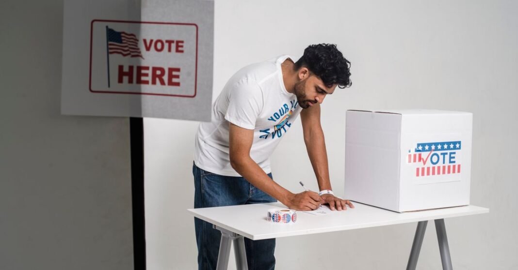 A young man at a polling station voting on election day, symbolizing democracy.
