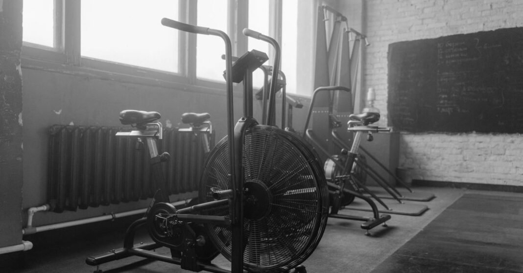 Black and white gym interior featuring exercise bikes and fitness equipment.