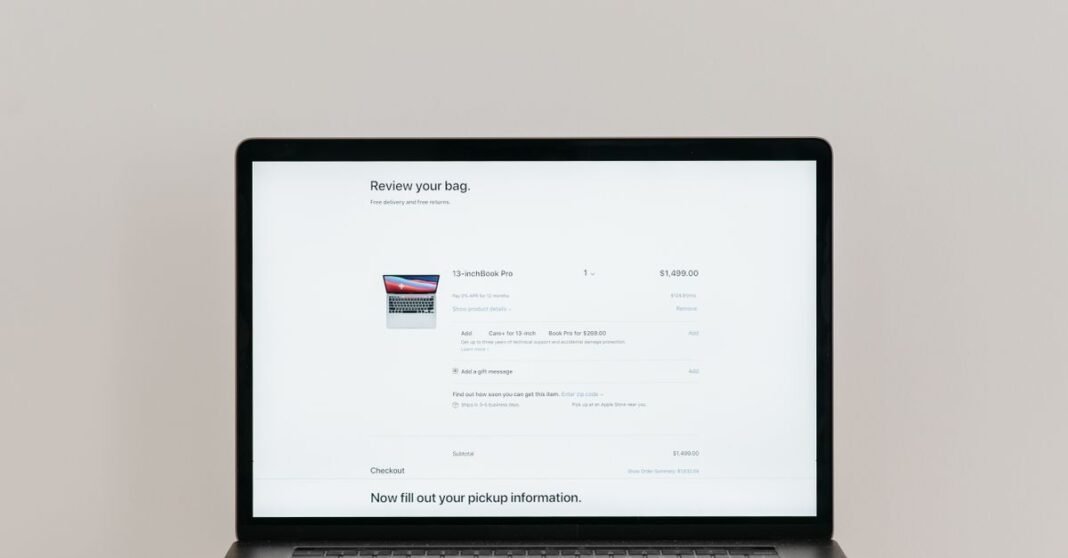 Minimalist laptop showing an online checkout screen on a white background, ideal for tech context.