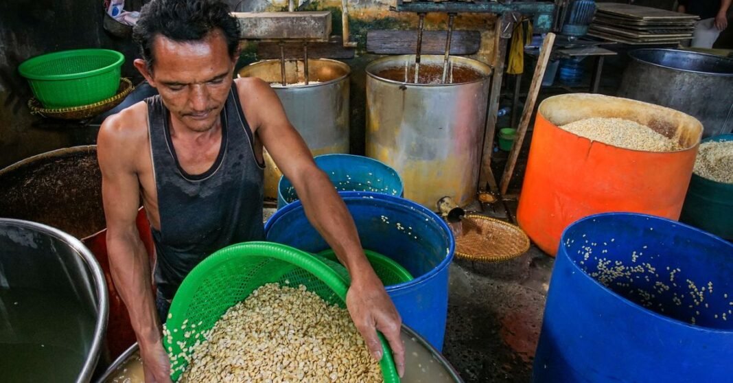 Man processing tofu in a traditional factory in Baleendah, Indonesia.